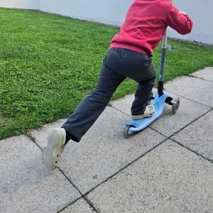 Child riding Banwood Eco Scooter in garden