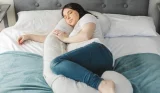Woman lying on bed using bellamoon pillow