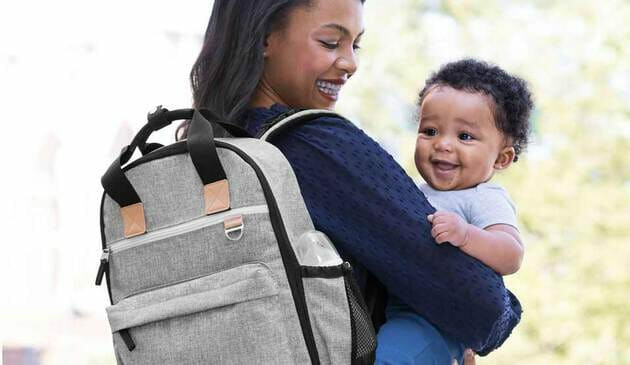 mother holding child and wearing backpack