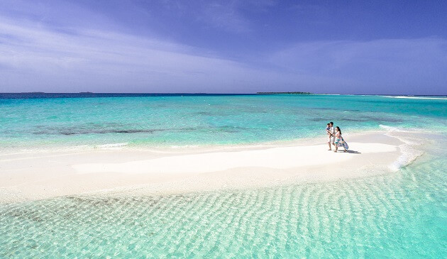 A family on a beach in the Maldives