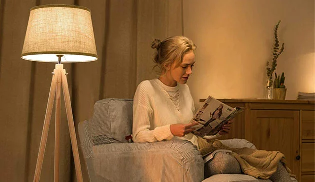 Woman reading by floor lamp light