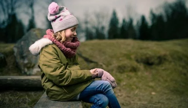 Girl wearing hat, coat and gloves