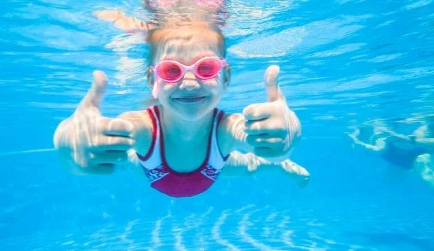 Child swimming underwater in a swimsuit
