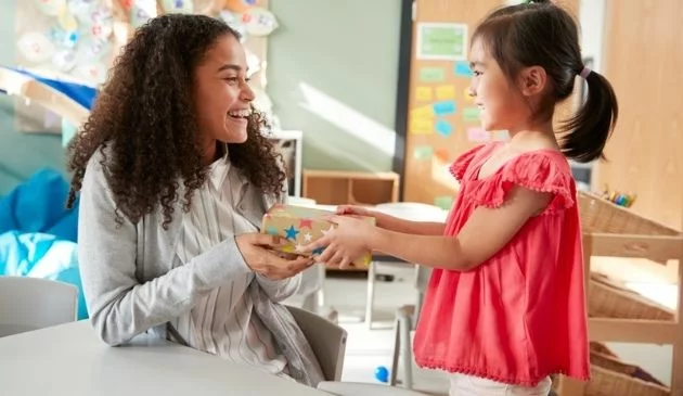 girl giving gift to teacher