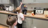 Two children help add fruits to the Braun MultiJuice 5 spin juicer during testing