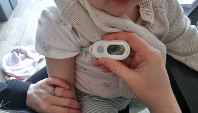 Child having temperature taken with the Braun Age Precision Digital Stick Thermometer