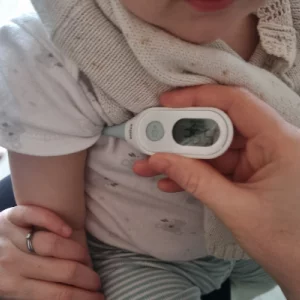 Child having temperature taken with the Braun Age Precision Digital Stick Thermometer