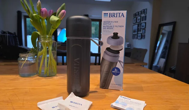 Blue BRITA Active bottle beside its box, two wrapped MicroDiscs and instructions on a wooden table