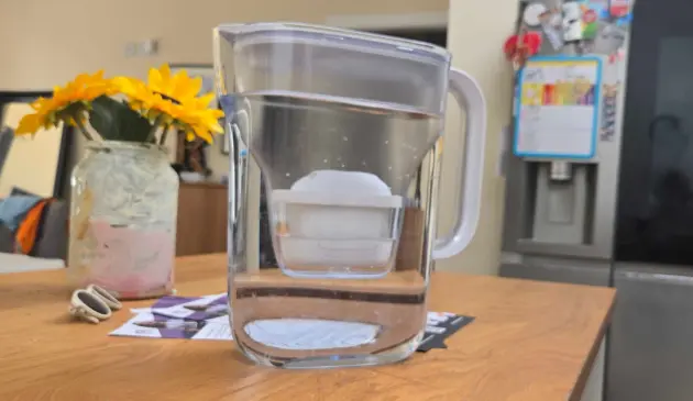 The Brita Style Essential Water Filter Jug on top of a kitchen counter filled with water