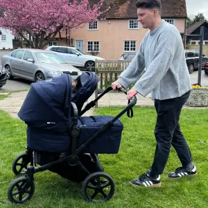 Man pushing Bugaboo Donkey 6 double buggy on grass