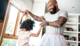 Father and daughter dancing together at home