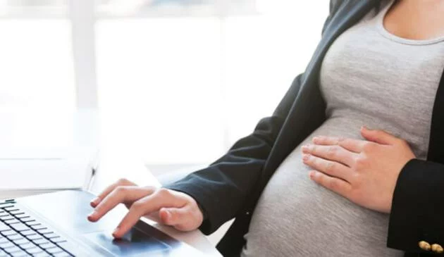 Woman at laptop touching bump