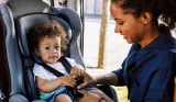 a child being secured in a car seat