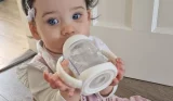 Child holding NUK First Choice Learner Bottle