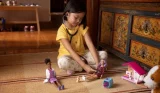 child playing doctors with Barbie dolls