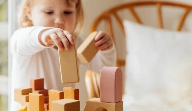 child playing with wooden blocks