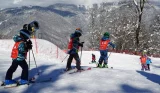Children taking part in a ski lesson on a ski slope