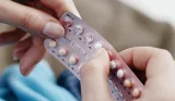 Woman holding packet of contraceptive pills