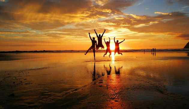 People jumping on a beach at sunset in Costa Rica