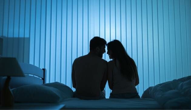 couple sitting on bed at night
