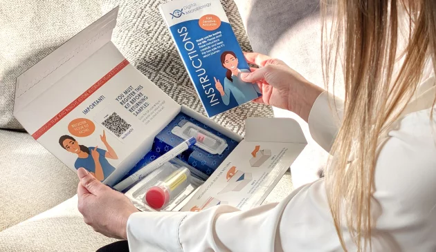 A woman holding a testing kit from Digital Microbiology