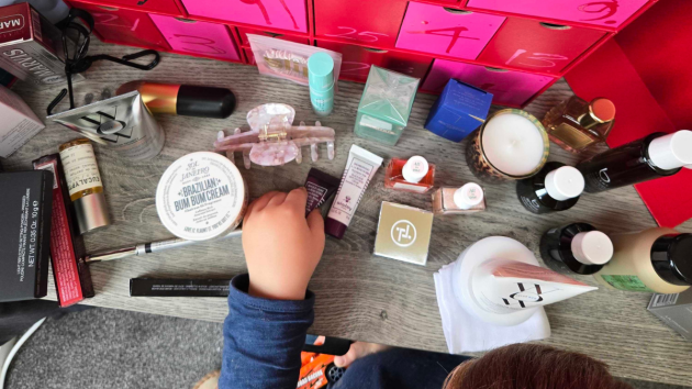 A child's hands helps to hold products from the Harvey Nichols beauty Advent calendar 2025