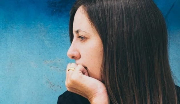 woman leaning on wrist in thought