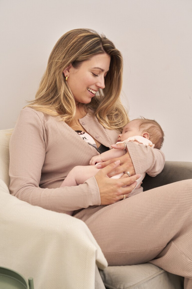 A mother cradles her baby while they sleep