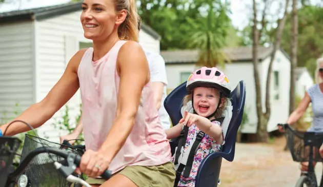 A woman and child on a bike at a Eurocamp site