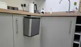 A view of the EKO Puro S Food Waste Caddy hanging on our tester's kitchen cupboard