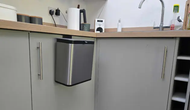 A view of the EKO Puro S Food Waste Caddy hanging on our tester's kitchen cupboard
