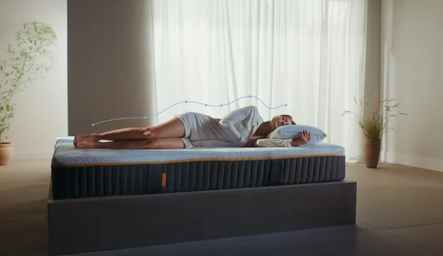 A woman sleeps on an Emma mattress