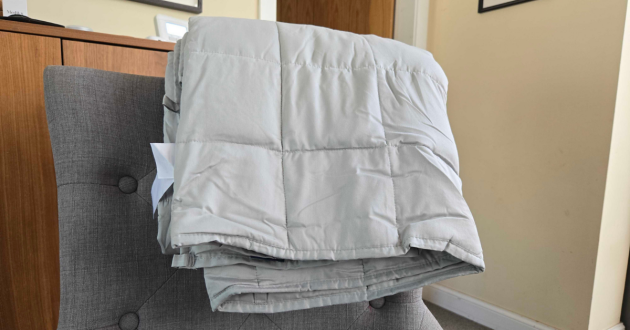 The Emma Hug Weighted Blanket folded on a chair
