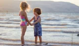 Toddlers holding hands in the sea