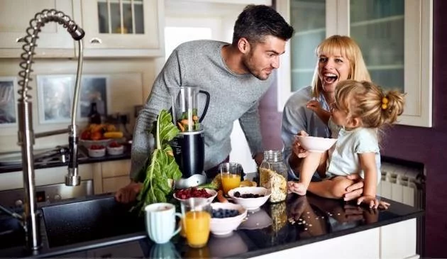 family of three eating healthy food in kitchen