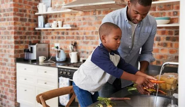 father and son washing vegetables