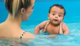 A mother and baby taking part in a Puddle Ducks swimming lesson