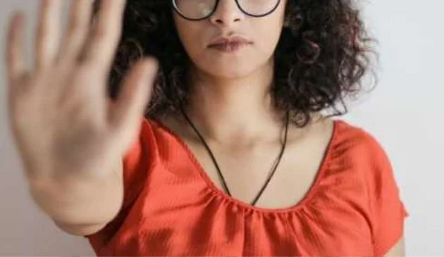Woman holding up hand in 'no' or 'stop' gesture