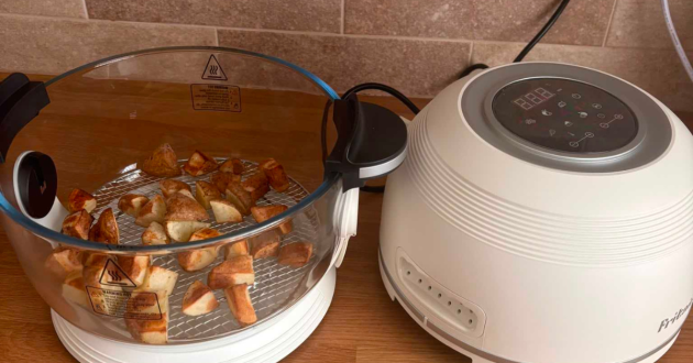 Cooked potato cubes on the air stand inside the Fritaire’s clear glass bowl, with the lid lifted beside it
