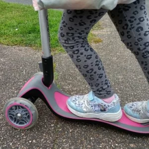 A close up of a child's feet on the Globber Primo scooter