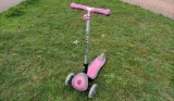 Pink Globber Primo scooter on the grass
