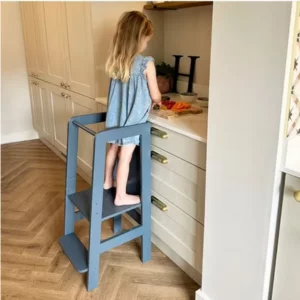 Child using Great Little Trading Co Kitchen Helper at kitchen worktop
