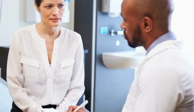 Woman talking to male doctor