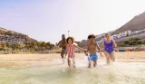 A family running in the sea in Gran Canaria
