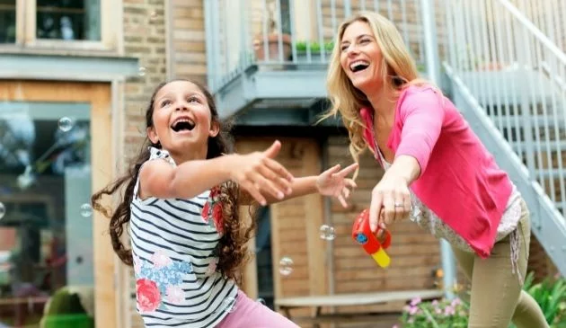 happy mum and daughter playing in garden