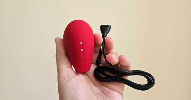The Lovehoney Heartbeat clit sucker toy with its magnetic charger