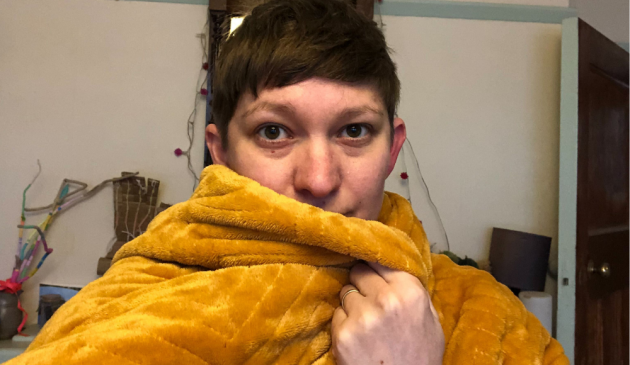 A woman wrapped in a yellow blanket