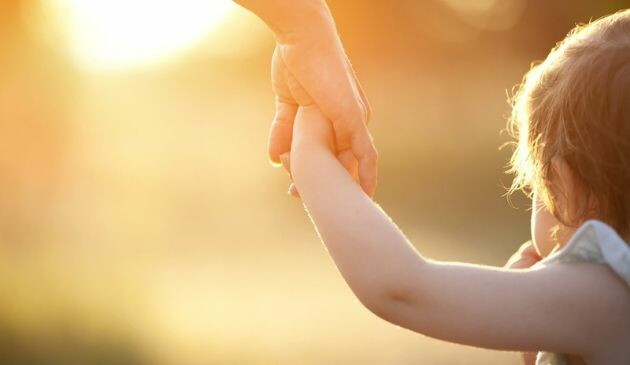 adult holding child's hand