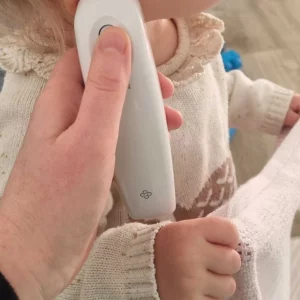 Mum holding Kinetik Inner Ear Thermometer to ear