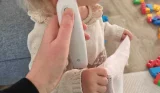 mum holding thermometer to child's ear